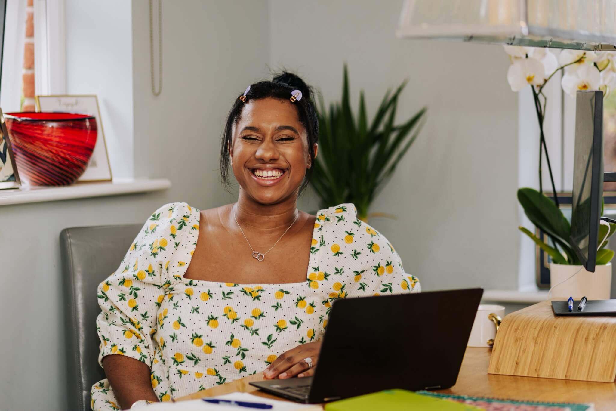 Chanelle, founder of Core People Solutions, smiling at her desk with a laptop